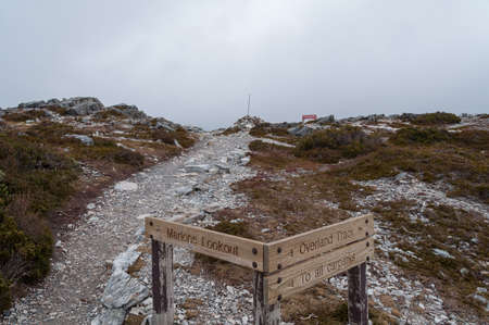 Tasmania, Australia - July 24, 2014: Overland hiking path with tourist navigation information boards, signs with tracks directions. Winter hiking, trekking in mountains landscapeのeditorial素材