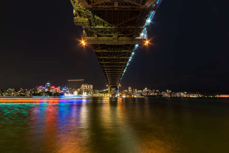 Modern cityscape at night background with bridge and water. Sydney cityscape illuminated at night の写真素材