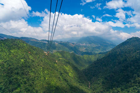 Cable car riding over green mountains and mountain valley. Travel adventures backgroundの写真素材