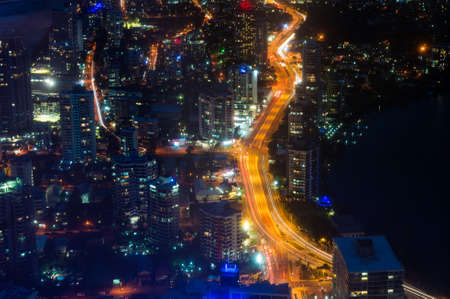 Aerial urban night traffic with busy highway. Modern city infrastructure, commercial district. Gold Coast, Australiaの写真素材