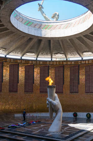 Volgograd, Russia - June 9, 2018: Eternal Flame in Hall of Military Glory on Mamayev Kurgan with monument of Motherland calls. Cyrillic text says Yes, we were mere mortals and only few of us survivedのeditorial素材