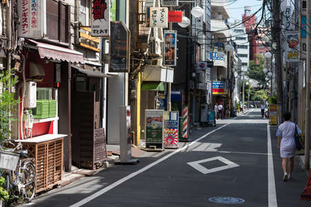 Tokyo, Japan - August 30, 2016: Tokyo street with residential and commercial property and people. Shinjuku commercial district of Tokyo, Japan. Signs in Kanji advertise local business and eateriesのeditorial素材