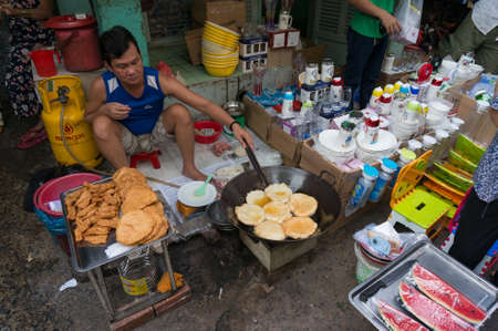 Ho Chi Minh, Vientam - August 25, 2017: Man cooking traditional Vietnamese fried snack in street food cafe. Cho Xom Chieu fresh food market in Ho Chi Minh Cityのeditorial素材