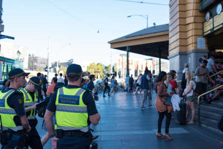 Melbourne, Australia - December 7, 2016: Police officers on duty near Flinders station in Melbourne at rush hour with crowds of people entering the stationのeditorial素材