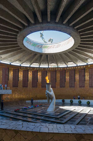 Volgograd, Russia - June 9, 2018: Eternal Flame on Mamayev Kurgan with monument of the Motherland calls visible. Cyrillic text says We were mere mortals and only few of us had survivedのeditorial素材