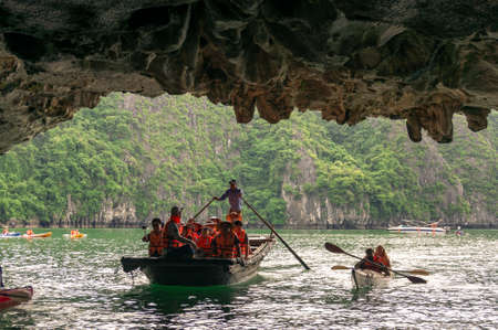 Halong Bay, Vientam - August 13, 2017: People in tour boat and kayaks exploring caves in Ha Long bay in Vietnamのeditorial素材