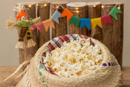 Popcorn served in a straw hat with party june decoration in the background. Festa Junina: Typical Brazilian June party. Closeup.の写真素材