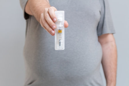 Obese young man holds an anticoagulant syringe to apply after bariatric surgery.の写真素材