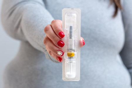 Obese young woman holds an anticoagulant syringe to apply after bariatric surgery. On the syringe is written: sale by prescription.の写真素材