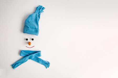 Christmas concept. Handmade snowman with scarf, hat and carrot on a white background. Flat layの写真素材