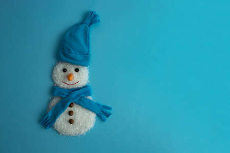 Christmas concept. Handmade snowman with snow, scarf, hat and carrot on a light blue background. Flat layの写真素材