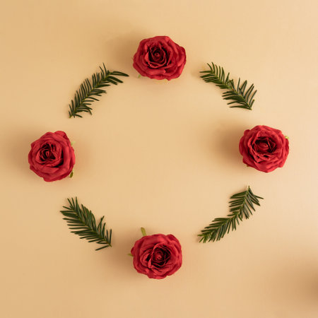 Red rose with Christmas tree branches on pastel yellow background. Flat lay, top view, copy spaceの写真素材