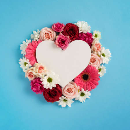 Heart shape copy space with colorful flowers. Valentines or woman's day background design. Minimal...