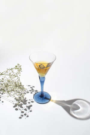 Creative composition with a glass and a branch of white flowers. Valentines or woman's day...