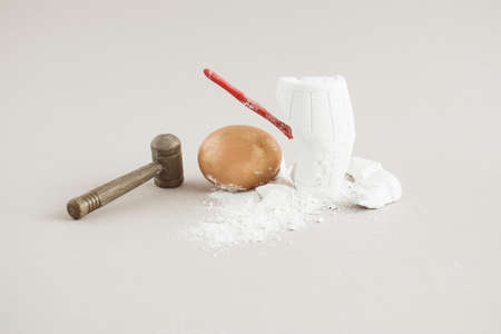 Creative composition with Easter golden egg, hammer, nail and old barrel with treasure. Minimal...