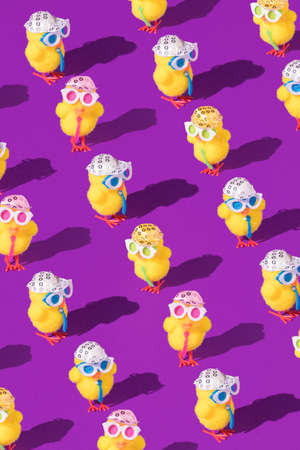 Minimal Easter pattern background with party chicken with hat, tie and glasses. Creative party or holiday concept. Copy space.の写真素材