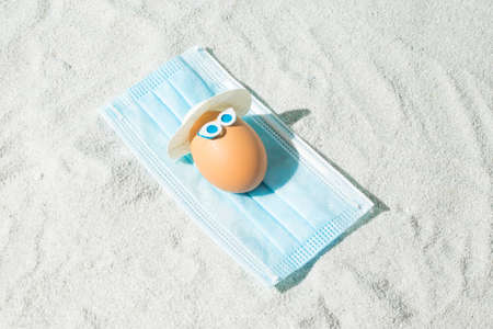 Summer Easter composition with eggs, virus mask and glasses. Minimal pandemic or holiday concept.の写真素材