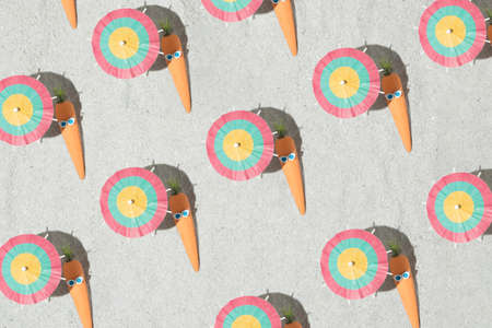 Creative Easter pattern background with carrots, glasses and beach umbrella on the sand. Summer and holiday idea. Flat lay.の写真素材