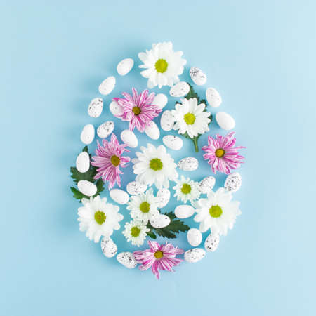 Creative Easter egg composition with spring flowers, eggs and green leaves. Contenmporary style. Flat lay. Top view.の写真素材