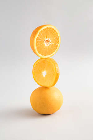 Creative summer composition with fresh oranges and slices on a blue and gray background. Minimal fresh nature or food concept.の写真素材