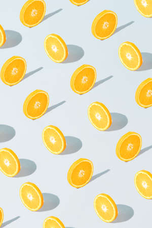 Pattern made with fresh sliced orange on the gray background. Minimal fruit or food concept. Flat...