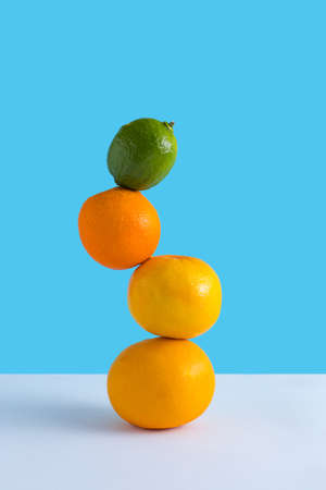 Summer composition with fresh orange, grapefruit and lime on a blue and white background. Creative healthy diet concept. Organic tropical fruit juice.の写真素材