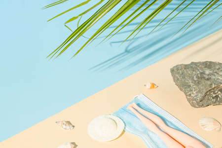 Summer sea scene with a doll, sea shells and a rock on the beach. Creative summer composition....