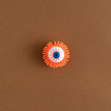 Creative colorful Halloween bloody eyeball on a brown background. Spooky concept.の写真素材