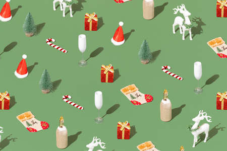 Trendy Christmas pattern with Christmas decorations, a bottle of champagne, a glass and a reindeer on a pastel green background. Minimal New year holiday wallpaperの写真素材