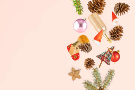 Creative arrangement with Christmas decorations, pine cones and pine twigs on a pastel beige...