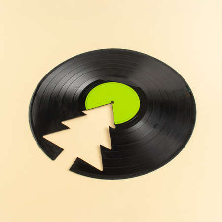 Trendy Christmas concept made of broken green label vinyl record and Christmas tree on beige background with copy space. Creative retro music background.の写真素材