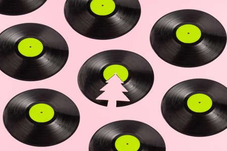Trendy Christmas pattern made of broken green label vinyl record on pink background with copy space. Creative retro music background.の写真素材