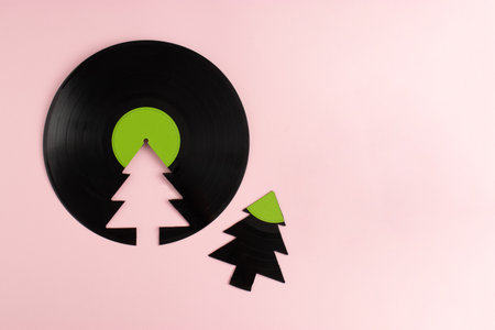 Trendy Christmas concept made of broken green label vinyl record and Christmas tree on pink background with copy space. Creative retro music background.の写真素材