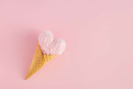 Ice cream cone with heart against pink background. Minimal love or Valentine's Day concept. Flat lay.の写真素材