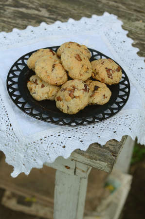 Homemade walnut cookies on vintage lace doily on rusted wooden tableの写真素材