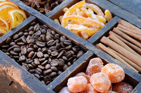 Coffee beans, kumquats, cinnamon, candied peels, dried orange slices and star anise in rusted wooden...