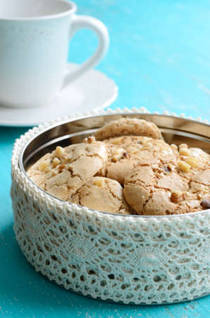 Homemade almond cookies wih walnuts in the box on blue background
