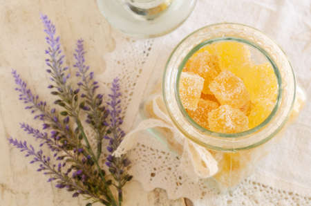 Homemade sugared orange jellies in glass jar and lavender on vintage lace doilyの写真素材
