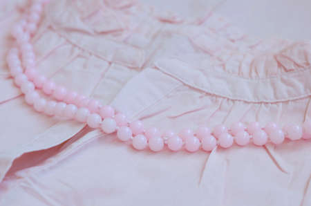 Pastel pink beads over vintage woman dressの写真素材