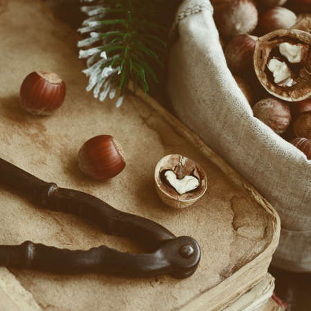 Decoration with nutcracker, heart shaped nut, old books and pine twigsの写真素材
