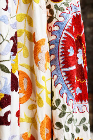 Suzani - traditional Uzbek embroidery fabric hanging at oriental bazar, selective focus