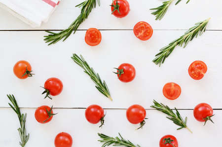 Cherry tomatoes and fresh rosemary on white backgroundの写真素材