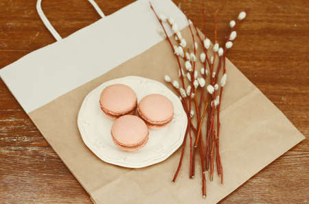 Caramel macarons on white plate and pussy willow bunchの写真素材