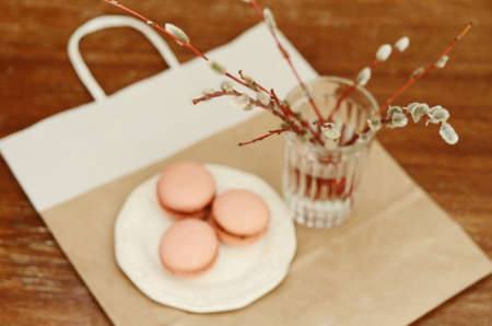 Pussy willow branches in glass and caramel macaroon, selective focusの写真素材
