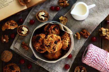 Homemade oatmeal cookies with nuts, raisin and dried cranberries and milk for breakfast. Baked with love.の写真素材