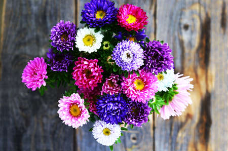 Bouquet of pink, violet and white aster over wooden background, top viewの写真素材