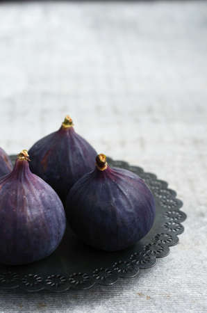 Ripe purple figs on metal plate, copy space on grey backgroundの写真素材