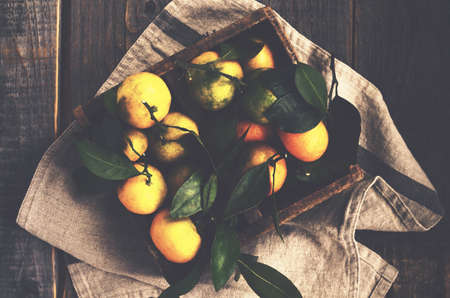 Fresh tangerines in rustic wooden box, top viewの写真素材