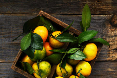 Fresh tangerines in rustic wooden box, top viewの写真素材