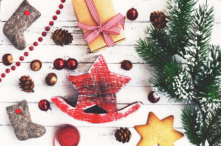 Xmas decoration with red wooden star, valenki, gingerbread cookies, gift and fir treeの写真素材